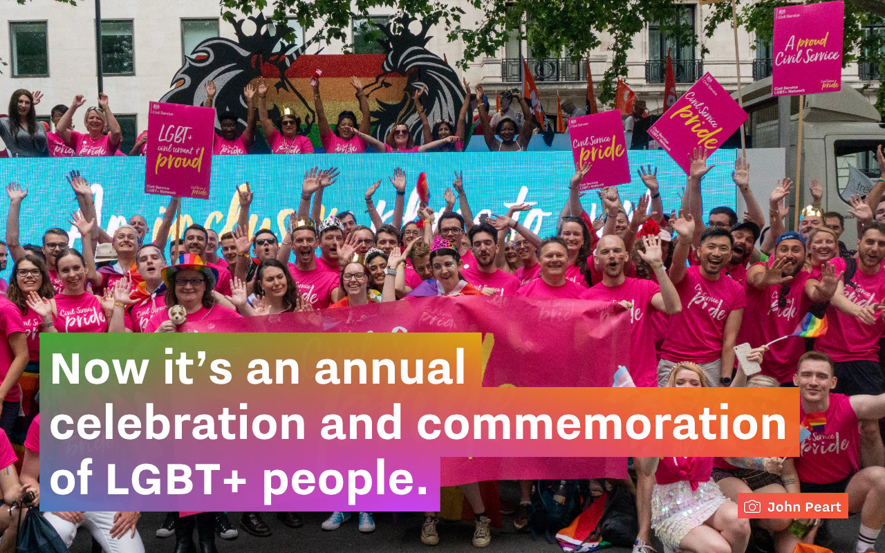 A screenshot of a slide with a photo of a group of civil servants gathered at Pride in London. Text: “Now it's an annual celebration and commemoration of LGBT+ people.”